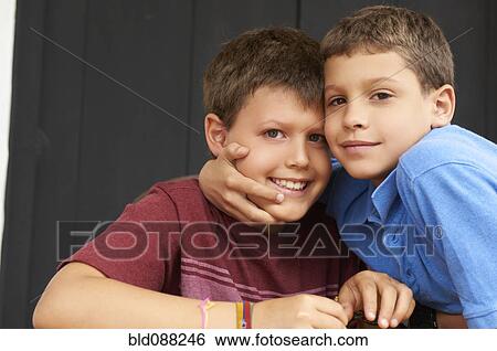 Stock Photograph - Smiling Hispanic boys hugging. Fotosearch