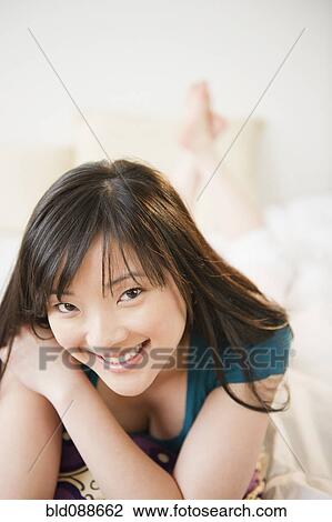 Smiling Korean woman laying down View Large Photo Image Stock Image - Smiling Korean woman laying down. Fotosearch