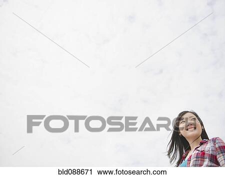 Stock Image - Smiling Korean woman outdoors. Fotosearch