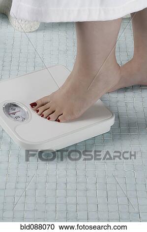 Woman stepping onto bathroom scale View Large Photo Image Stock Image - Woman stepping onto bathroom scale. Fotosearch