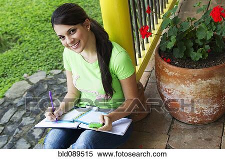 Stock Photography - Woman studying and holding cell phone. Fotosearch