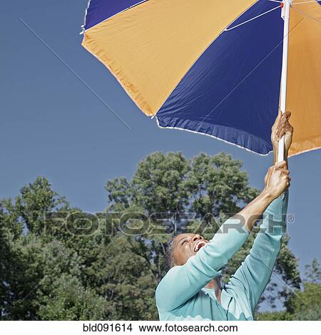 African American woman lifting umbrella View Large Photo Image Picture - African American woman lifting umbrella. Fotosearch