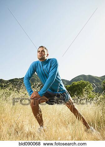 Athletic mixed race man stretching outdoors before exercise View Large Photo Image Stock Photo - Athletic mixed race man stretching outdoors before exercise. Fotosearch