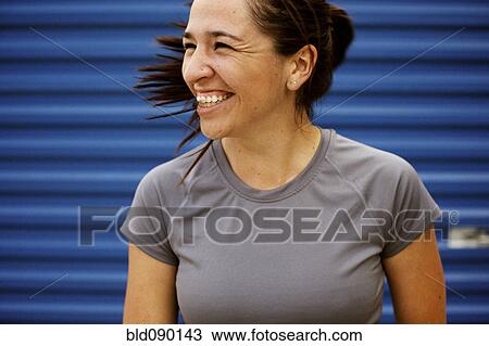Stock Image - Athletic mixed race woman laughing outdoors. Fotosearch
