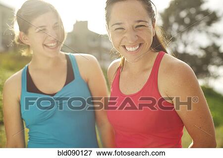 Stock Photo - Athletic women smiling together outdoors. Fotosearch