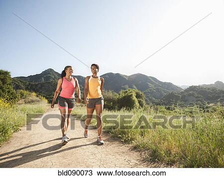 Athletic women walking together on remote trail View Large Photo Image Stock Image - Athletic women walking together on remote trail. Fotosearch