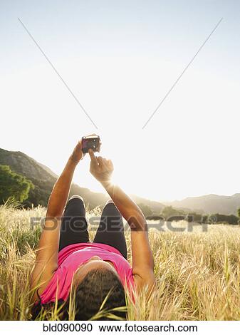 Black woman laying in field using cell phone View Large Photo Image Stock Image - Black woman laying in field using cell phone. Fotosearch