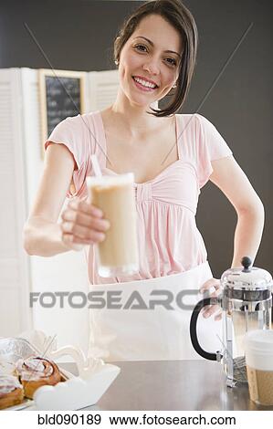 Stock Photo - Brazilian waitress holding out iced coffee. Fotosearch