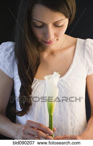Stock Photo - Brazilian woman holding calla lily. Fotosearch
