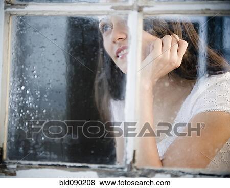 Stock Photo - Brazilian woman looking out window. Fotosearch