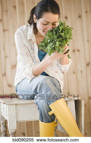 Stock Photography - Brazilian woman smelling fresh mint. Fotosearch