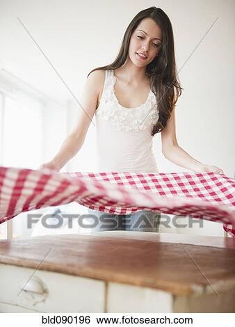 Stock Photograph - Brazilian woman spreading tablecloth. Fotosearch