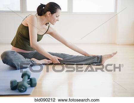 Stock Image - Brazilian woman stretching before exercise. Fotosearch