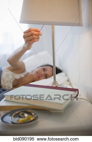 Brazilian woman turning of lamp in bedroom View Large Photo Image Stock Photography - Brazilian woman turning of lamp in bedroom. Fotosearch
