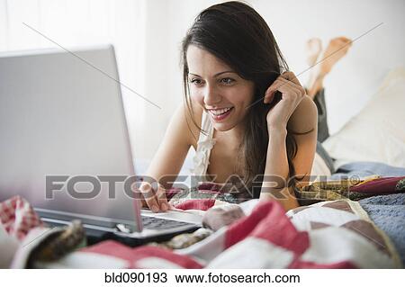 Brazilian woman using laptop in bed View Large Photo Image Stock Image - Brazilian woman using laptop in bed. Fotosearch