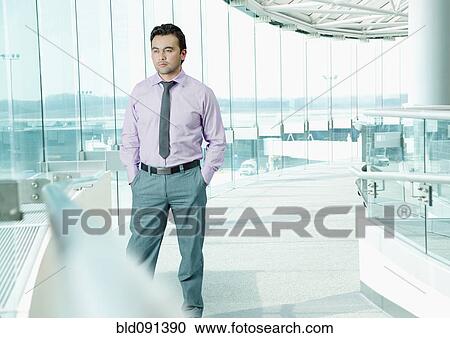 Stock Image - Businessman standing in airport. Fotosearch