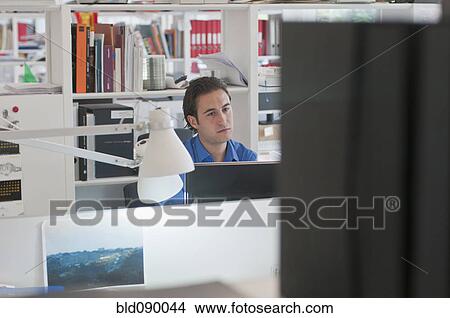Picture - Businessman working at desk in office. Fotosearch