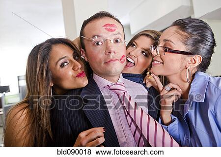 Stock Photo - Businesswomen kissing male co-worker. Fotosearch