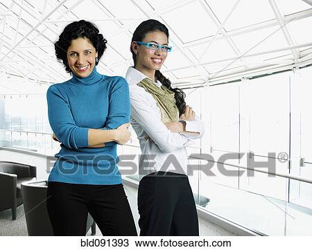 Stock Image - Businesswomen standing in airport. Fotosearch