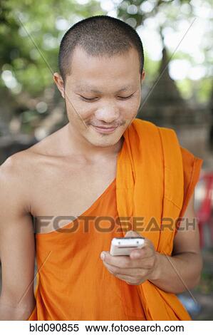 Cambodian monk text messaging on cell phone View Large Photo Image Stock Photography - Cambodian monk text messaging on cell phone. Fotosearch