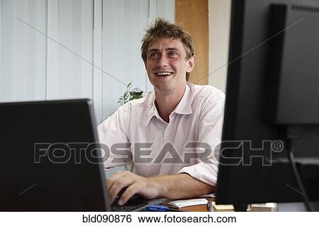 Stock Photograph - Caucasian businessman working at desk. Fotosearch