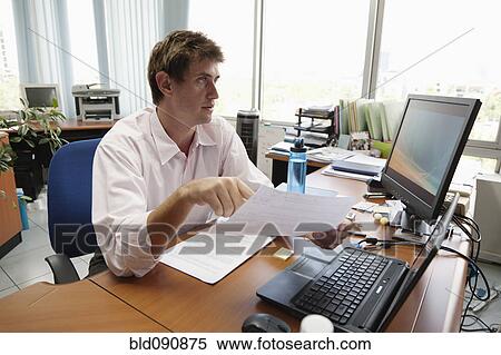 Stock Photography - Caucasian businessman working at desk. Fotosearch