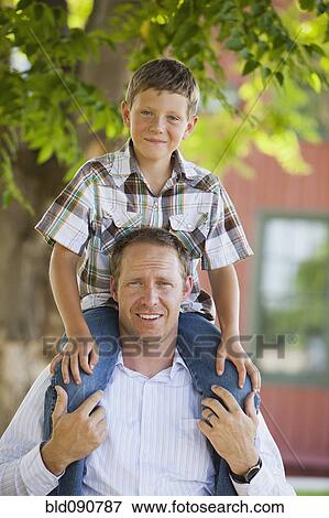 Caucasian father carrying son on shoulders View Large Photo Image Stock Photo - Caucasian father carrying son on shoulders. Fotosearch