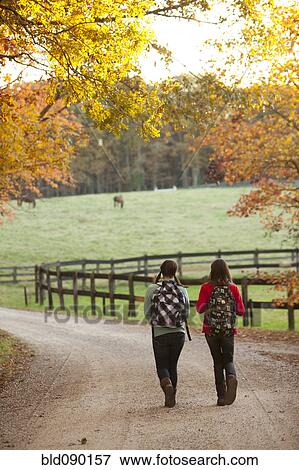 Caucasian girls walking together on road in countryside View Large Photo Image Stock Photo - Caucasian girls walking together on road in countryside. Fotosearch