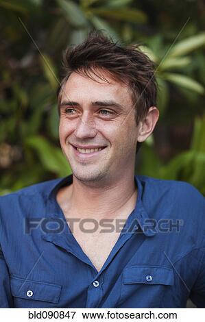 Stock Photo - Caucasian man reading book outdoors. Fotosearch