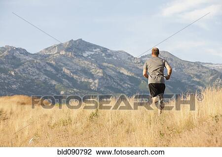 Stock Image - Caucasian man running in remote area. Fotosearch