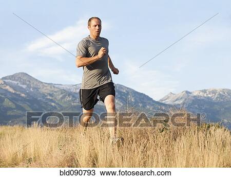 Stock Image - Caucasian man running in remote area. Fotosearch