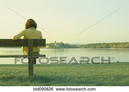 Stock Photograph - Caucasian teenage girl sitting on park bench. Fotosearch
