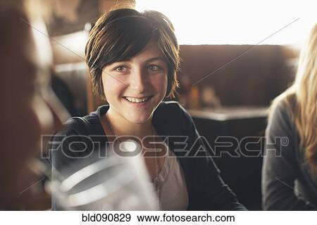 Stock Photo - Caucasian teenager in restaurant with friends. Fotosearch