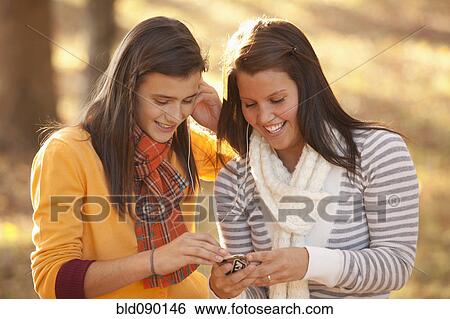 Caucasian teenagers sharing mp3 player View Large Photo Image Stock Photograph - Caucasian teenagers sharing mp3 player. Fotosearch