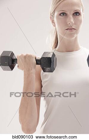 Stock Image - Caucasian woman exercising with dumbbells. Fotosearch