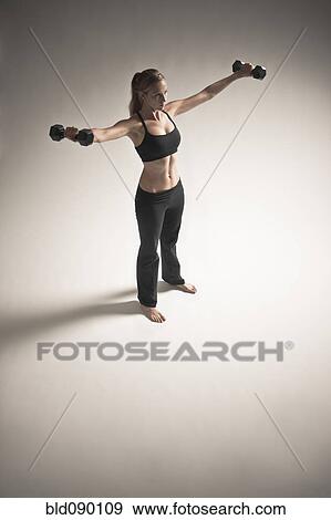 Caucasian woman exercising with dumbbells View Large Photo Image Stock Photo - Caucasian woman exercising with dumbbells. Fotosearch
