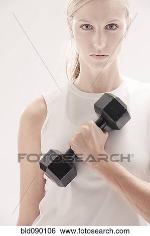Stock Photograph - Caucasian woman exercising with dumbbells. Fotosearch