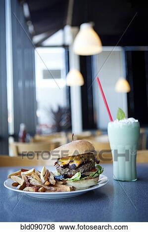 Cheeseburger, french fries and milkshake in diner View Large Photo Image Stock Photo - Cheeseburger, french fries and milkshake in diner. Fotosearch