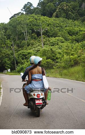 Couple riding scooter in remote area View Large Photo Image Stock Image - Couple riding scooter in remote area. Fotosearch