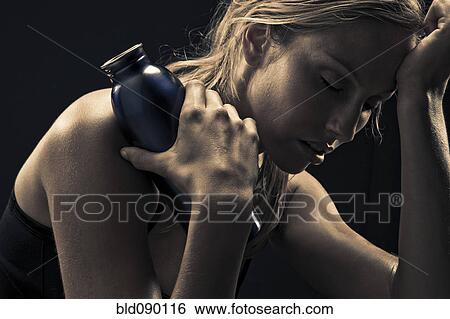 Stock Photograph - Fatigued Caucasian woman holding water bottle. Fotosearch