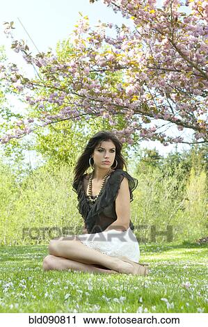 Glamorous Caucasian woman sitting in grass View Large Photo Image Stock Image - Glamorous Caucasian woman sitting in grass. Fotosearch