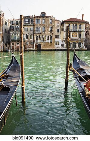 Gondolas moored in canal on wooden posts View Large Photo Image Stock Image - Gondolas moored in canal on wooden posts. Fotosearch