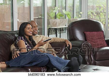 Stock Image - Happy couple watching television together. Fotosearch