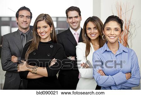 Stock Image - Hispanic business people standing together in office. Fotosearch