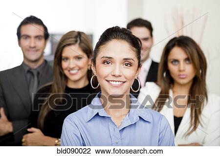 Stock Image - Hispanic business people standing together in office. Fotosearch