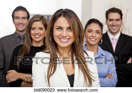 Stock Image - Hispanic business people standing together in office. Fotosearch