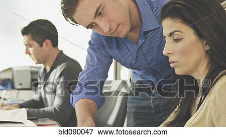 Stock Photo - Hispanic business people working together in office. Fotosearch
