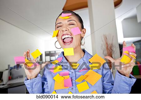 Picture - Hispanic businesswoman covered in sticky notes. Fotosearch