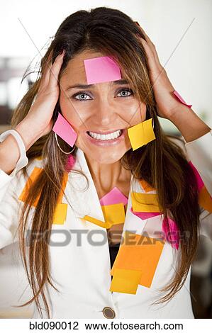 Stock Image - Hispanic businesswoman covered in sticky notes. Fotosearch