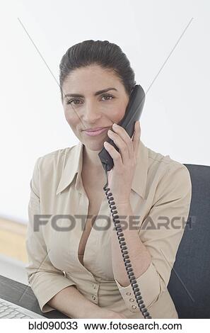Stock Image - Hispanic businesswoman talking on telephone. Fotosearch